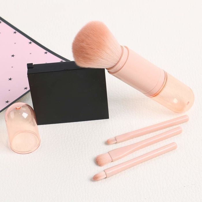 The brush set is neatly arranged beside a compact mirror.