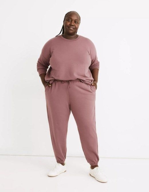 plus-sized model rocking the dusty rose sweats with white sneakers and a coordinating sweatshirt