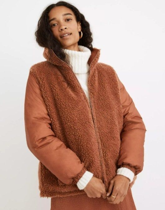A model sporting a tan jacket with a fuzzy Sherpa front on the outside.
