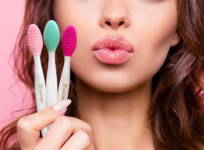 a model holding three lip exfoliating brushes