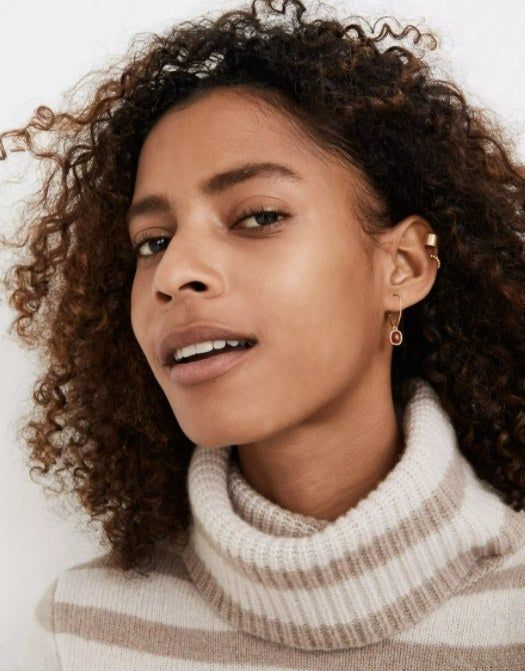 model showcasing the stone hoop earrings in vibrant red, paired with a striped white and brown turtleneck