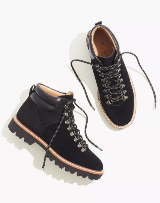 the hiking boots in black, with one boot positioned on its side to highlight the high-ankle design