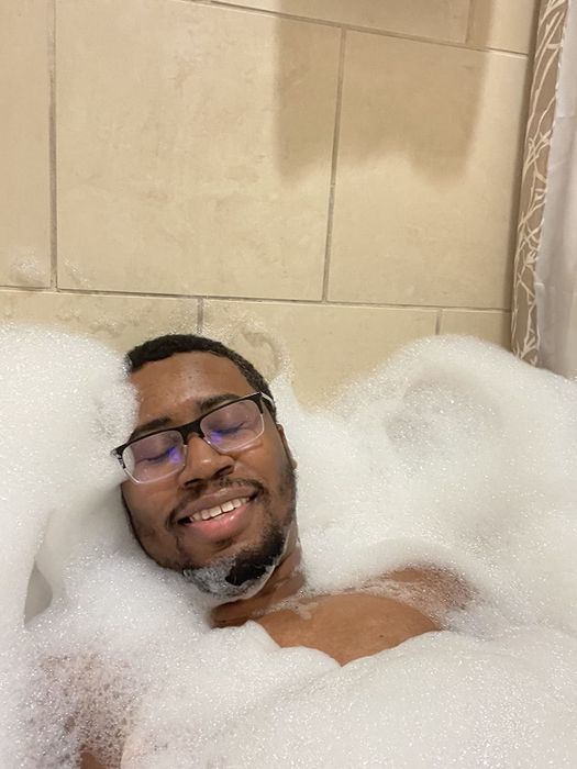 a man smiling in a bubble-filled bath