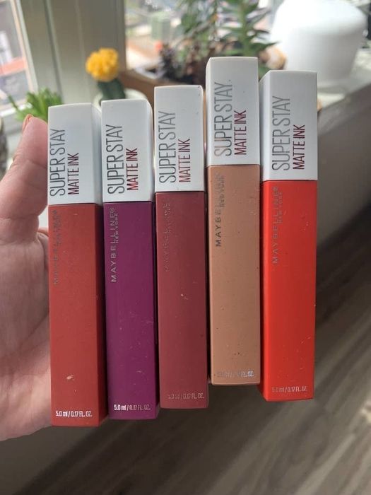 A Mytour writer holding five square tubes of the lipstick in various shades