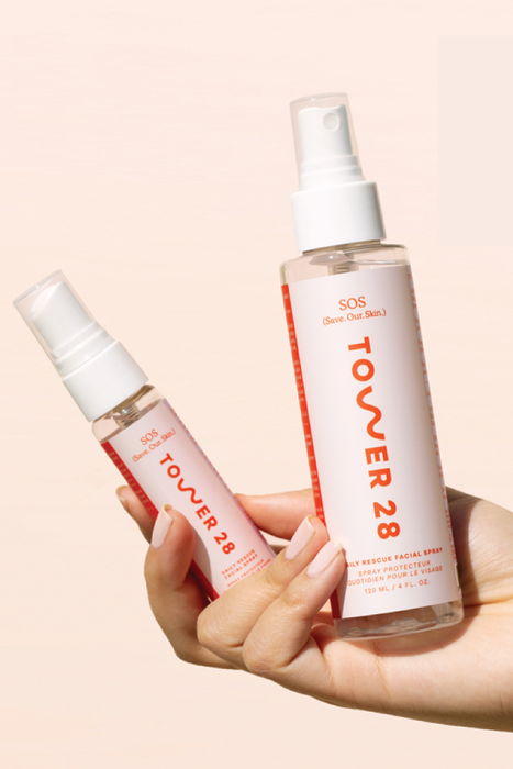 A model holds both the mini and full-size bottles in one hand.