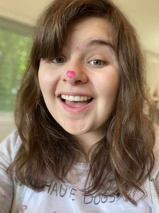 editor wearing a pink heart-shaped patch on her nose