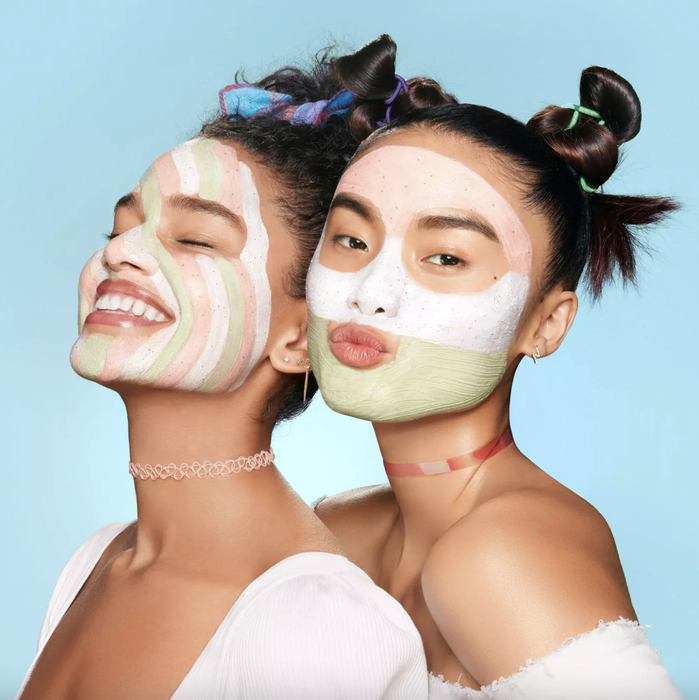 Two models applying each of the masks from the set on their faces