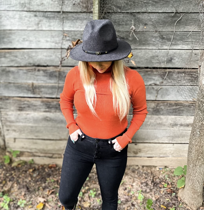 reviewer modeling the orange sleeved top