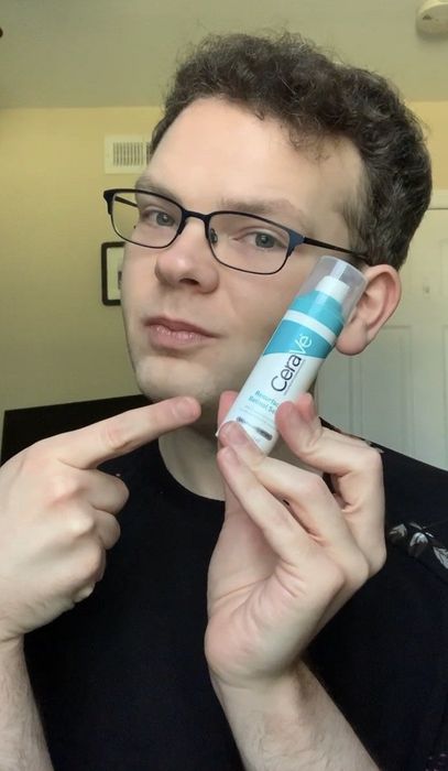 Mytourer holding a bottle of CeraVe Resurfacing Retinol Serum