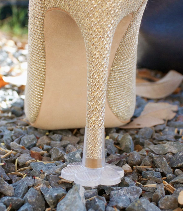 plastic flower-shaped cap on a stiletto heel, preventing it from sinking into gravel