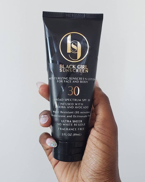 A Mytour editor holding a tube of Black Girl Sunscreen.