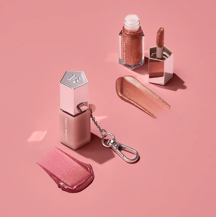 The two mini glosses next to their swatch samples, Pink Dragonfly in the keychain holder on the left and the open Fenty Glow on the right.