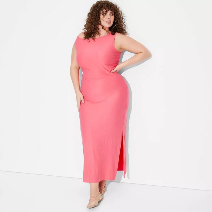 The model is wearing a sleeveless maxi dress with a thigh-high slit.