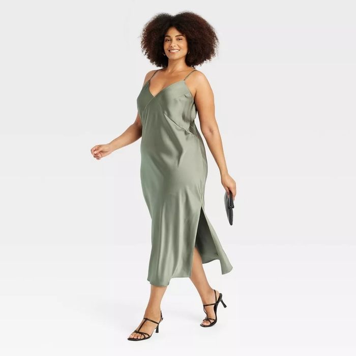 The model is wearing a sleeveless slip dress with a side slit.