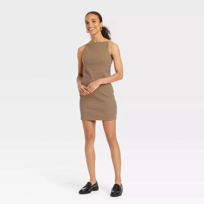 Model showcasing a sleeveless, striped, knee-length dress paired with black loafers