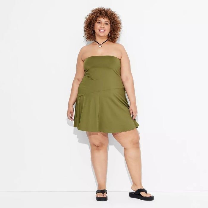 The model is styled in a strapless, knee-length, casual olive green dress paired with black sandals.