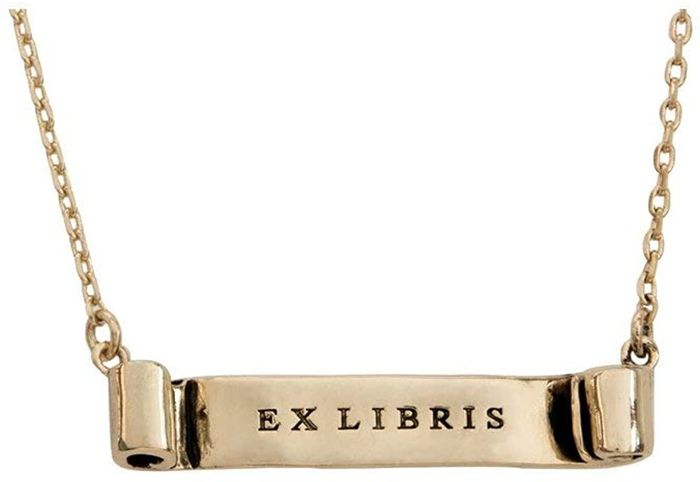 A gold-tone necklace featuring a scroll with the inscription "ex libris"