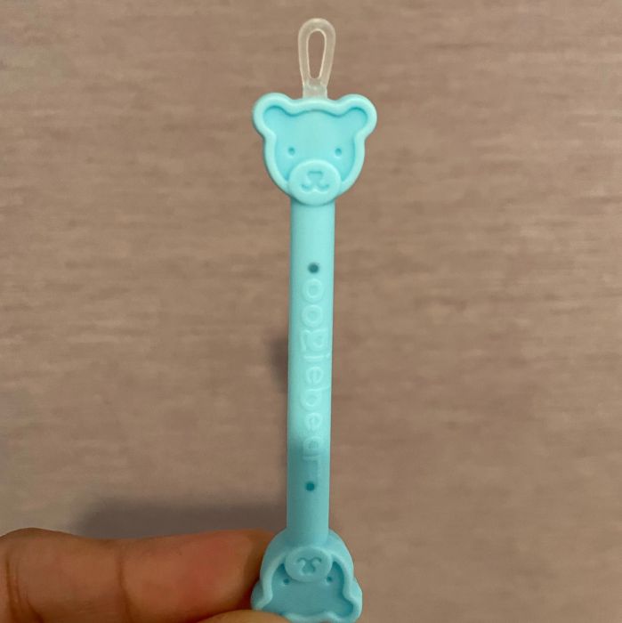 A close-up view of the bear-shaped booger cleaner tool