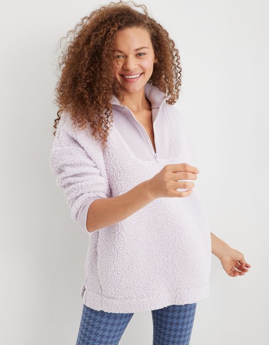 model in a lavender sherpa jacket with a ribbed panel around the quarter zip