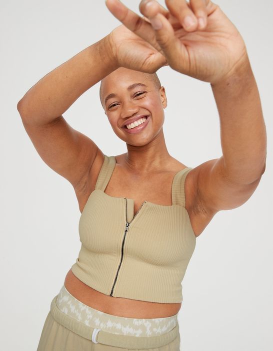 model wearing a tan square-neck tank with a zip-up front