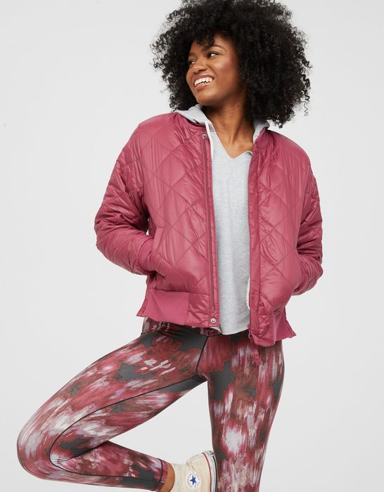 Model wearing a pink bomber jacket with pockets.