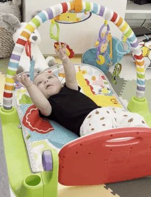A gif of a baby kicking the Fisher-Price piano