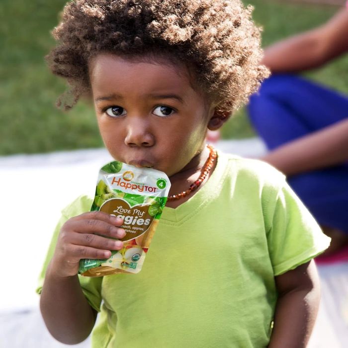 A toddler enjoying a Happy Tot pouch