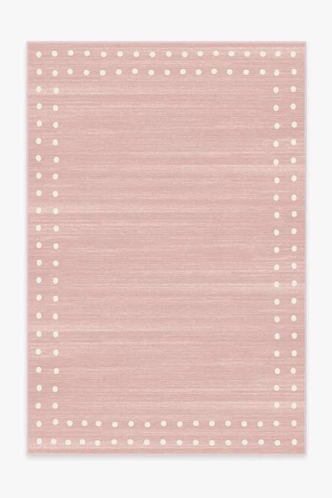 A pink Ruggable rug with a white polka dot border