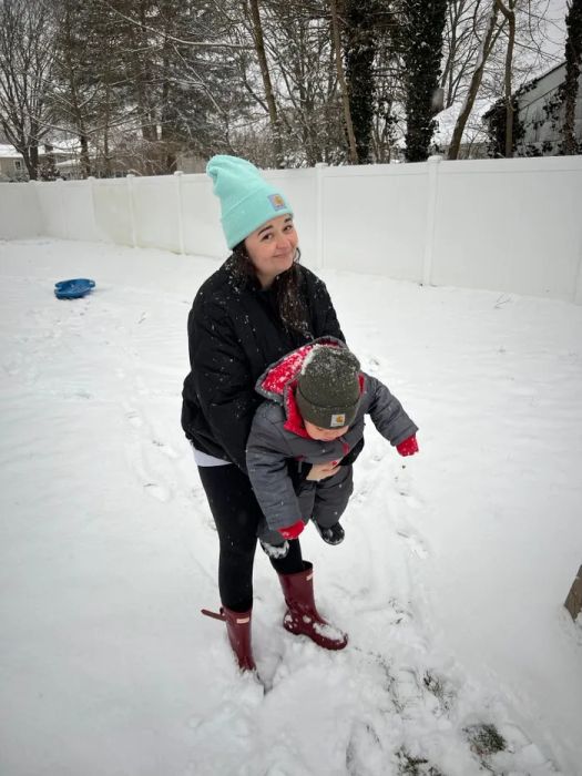 Mytour editor cradling her toddler son in a snowy setting