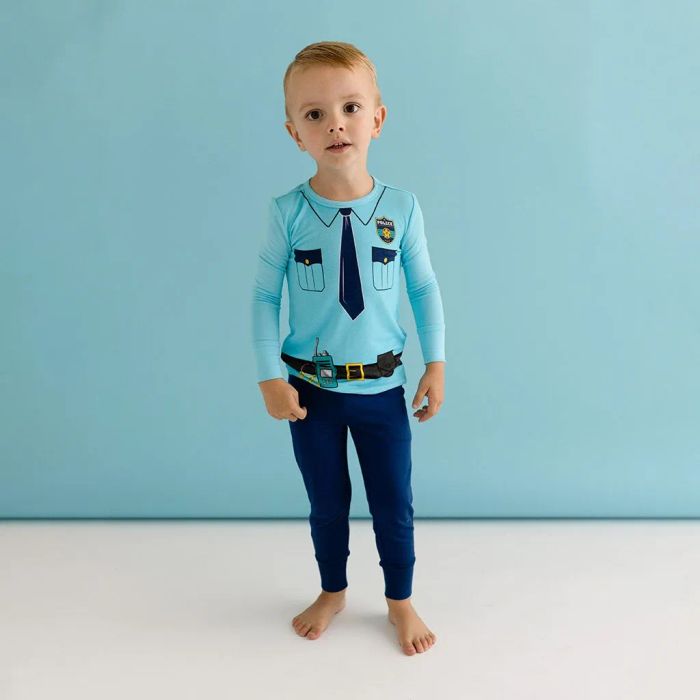 A child wearing a two-piece police officer pajama set