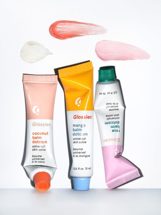 Three tubes of Balm Dotcom in coconut, mango, and rose variants