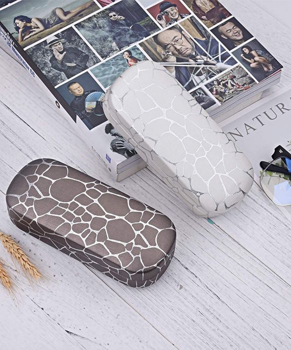 the case in white and brown, featuring a silver giraffe print on each side