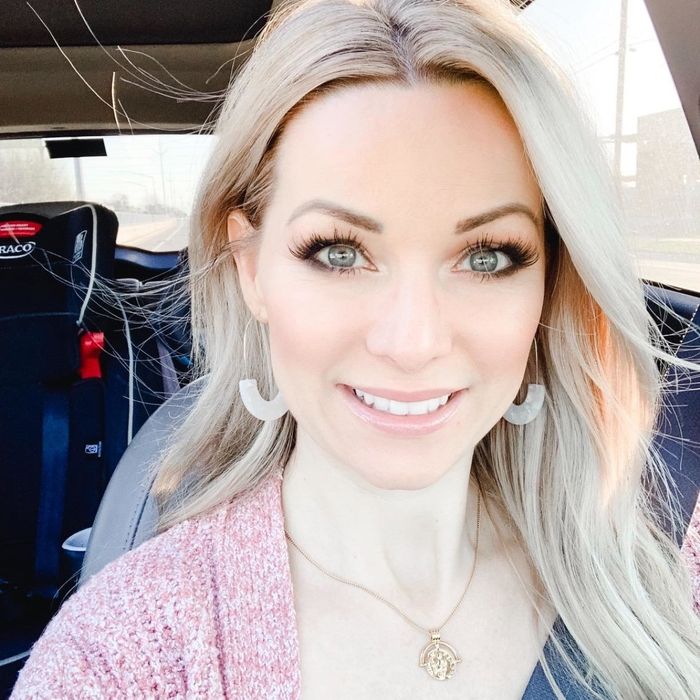 a reviewer showcasing the gold and off-white acrylic earrings