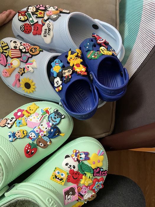 a reviewer's Crocs adorned with an assortment of colorful charms