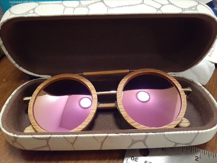 a pair of oversized round sunglasses stored in the case