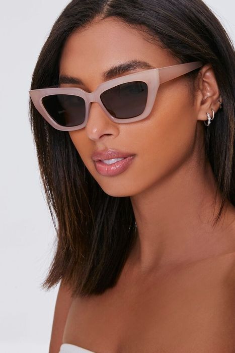 a model wearing the light pink sunglasses