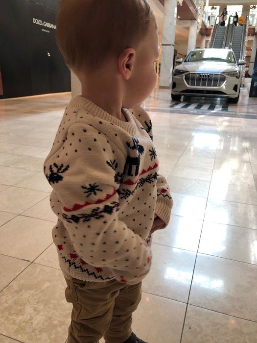 A child modeling the white sweater.