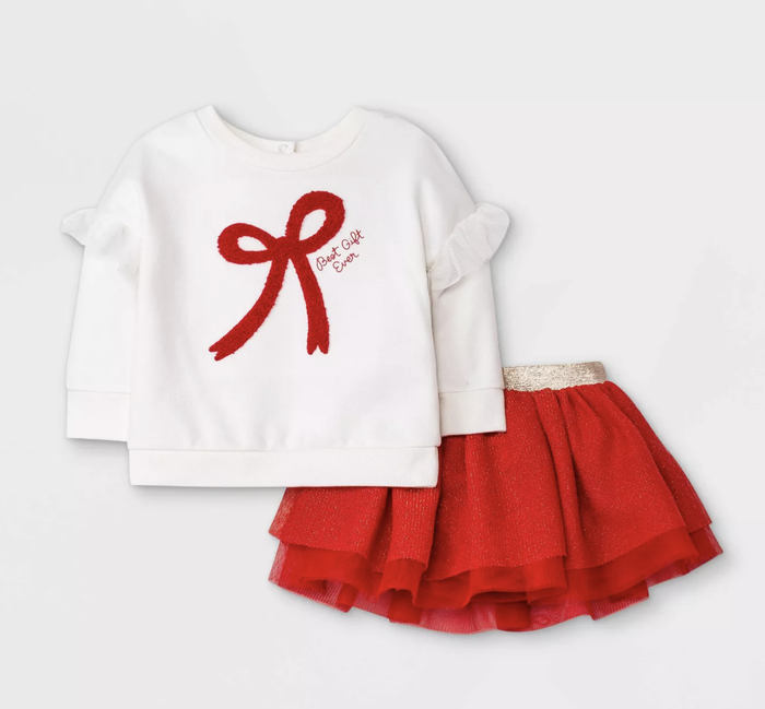 A white long-sleeve top with a red bow and a red tulle skirt.