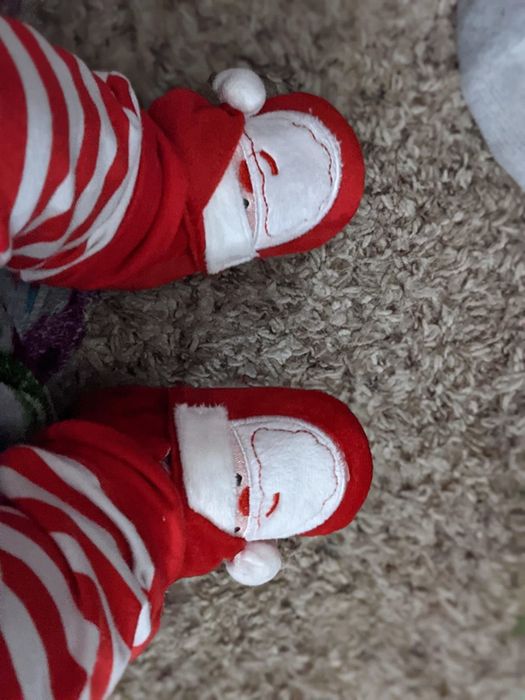 A reviewer's baby wearing tiny Santa shoes.