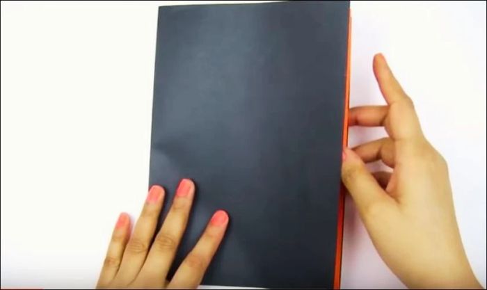 Gấp đôi tờ giấy bìa màu đen