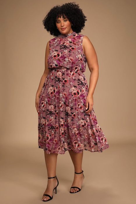 The model is wearing a mauve midi dress adorned with floral patterns.
