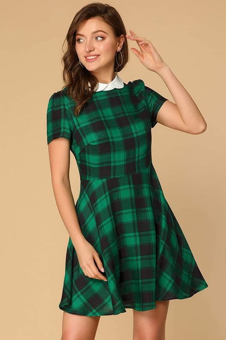 A model showcasing a green and black plaid fit-and-flare dress with short sleeves and a crisp white collar