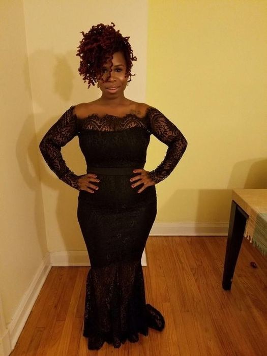 reviewer wearing a black form-fitting dress with long lace sleeves