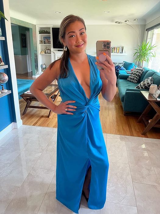 Reviewer in a blue twist-front satin floor-length gown
