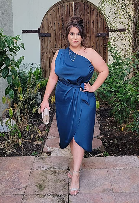 A reviewer wearing the blue satin dress