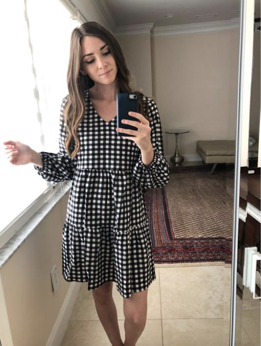 reviewer showcasing the dress in a black-and-white checkered pattern