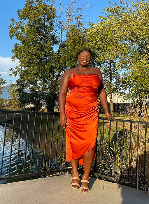 a reviewer wearing the dress in a vibrant orange shade