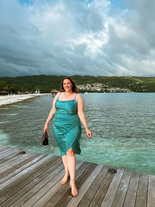 A reviewer in the forest green satin dress, sharing their experience with its elegant fit, rich color, and versatility.