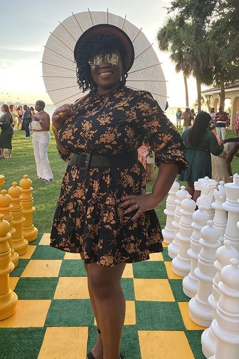 another reviewer wearing the dress at a wedding, holding a parasol
