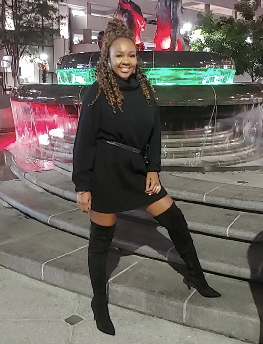 Reviewer styled in a sleek black dress